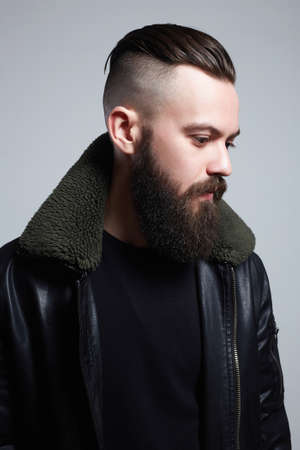 Man with stylish haircut. handsome Boy with beard. Brutal bearded hipster in vintage leather aviator...