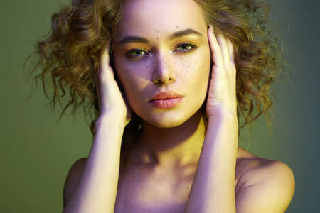 Beautiful woman in green Light. amazing curly girl with make-up. beauty fashion portrait. frizzle...