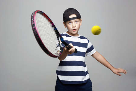 Little Boy Playing Tennis. Sport kid. Child with tennis racquet and ball