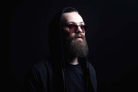 Handsome Man in Hood and sunglasses. Boy in a hoodie. portrait of bearded man