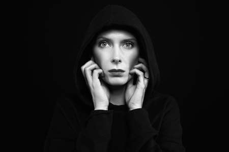 beautiful woman in hood. Monochrome portrait of woman in the darkの写真素材