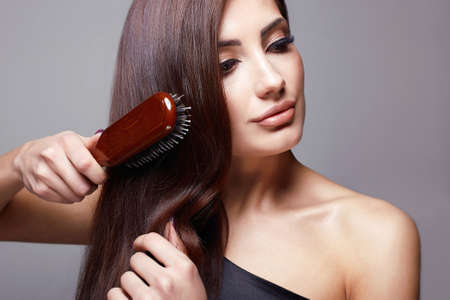 Beautiful girl combing her hair. Beautiful Hair care. fashion beauty portrait of beautiful woman with healthy Hairの写真素材