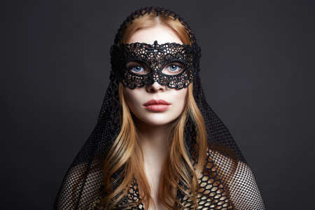 Beautiful young Woman in a Carnival Mask. Masquerade. Sexy Girl in mask. Beauty & Fashionの写真素材