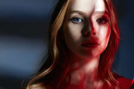 Sensual beautiful young Woman in red light. Sweet blond Girl in Nightlight from a window