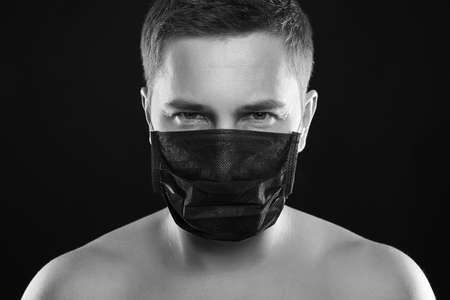 Man in Mask. Boy in Black Mask. Male black and white portrait. Coronavirus epidemicの写真素材