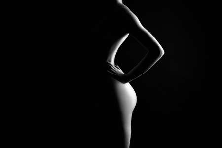 Black and white Female Nude silhouette. Naked Woman. Girl in darkの写真素材