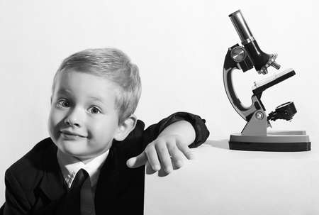 Portrait of funny child. little scientist. fashion portrait of little boy in tie. Schoolboy working with a microscope. Smart kid. Educationの写真素材