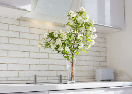 Jasmine on a kitchen table. Beautiful Flowers in contemporary interior. Fresh bouquet of jasminの写真素材