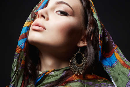 closeup portrait of beautiful young woman in color veil and jewelry. beauty girl in colorful hijab. fashion oriental styleの写真素材