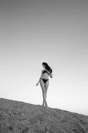 beautiful woman in bikini standing on sand in the desertの写真素材