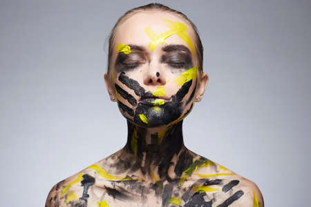 portrait of Beautiful Young woman with Paint on her Face and Body. Girl with halloween make-upの写真素材