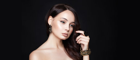 pretty young brunette woman with jewelry. beautiful girl with make-up and jeweleryの写真素材