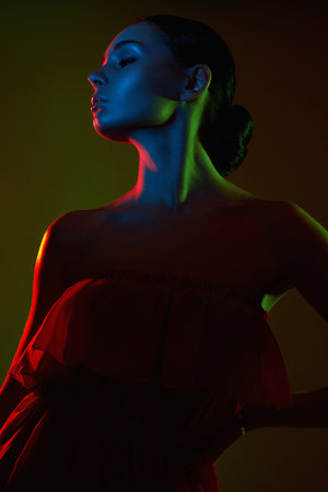 Beautiful Woman in Colorful bright lights. silhouette of Girl in red dressの写真素材