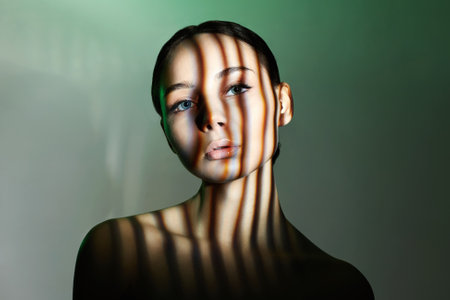 light on the face of beautiful girl. sensual young woman in shadowsの写真素材