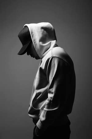Young Man in Hat and Hood. Boy in a hooded sweatshirt Black and white portraitの写真素材