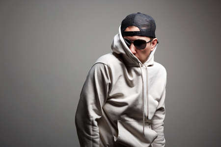 Man in Hood, Hat and sunglasses. stylish Boy in a hooded sweatshirt. Male portrait