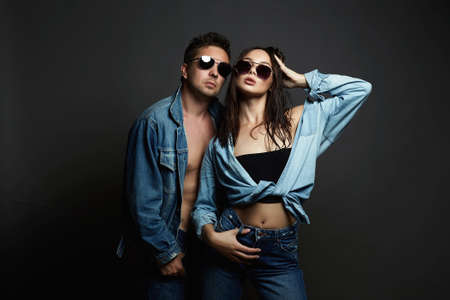 gorgeous fashion beautiful couple wearing trendy glasses and posing together. Hipster boy and wet...