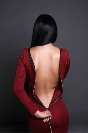 beautiful back of young woman in a red sexy dress. beauty brunette girlの写真素材