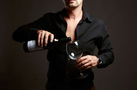 Man with Wine. Adult brutal Man with bottle of wine and wineglassの写真素材