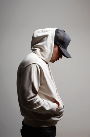 Young Man in Hat and Hood. Boy in a hooded sweatshirt posing in studio