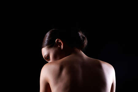 Female Back silhouette. Naked Woman. Sensual Girl in dark. Beautiful backの写真素材