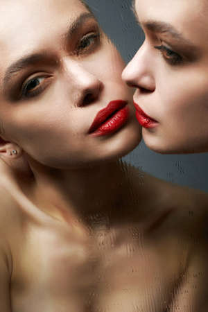 Beautiful Girl with mirror. Sensual Young woman with red lips make-upの写真素材