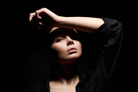Fashion portrait of young beautiful woman in dark. sexy girl on black backgroundの写真素材
