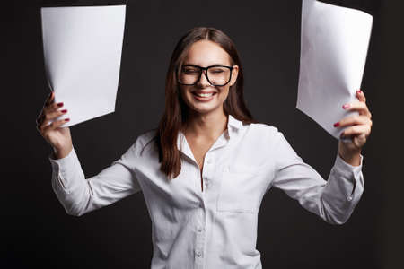 beautiful happy girl in glasses holding paper. portrait of smiling business womanの写真素材
