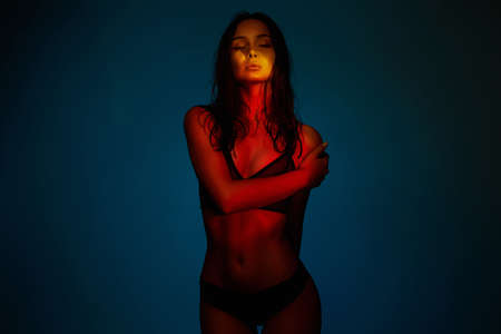 Sexy woman in Underwear. Wet Hair Beautiful Girl in Rainbow color lightsの写真素材