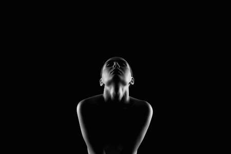 Nude Woman silhouette under light in the dark. Beautiful Sexy Naked Body Girlの写真素材