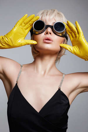 Unusual futuristic glasses. beautiful blonde hair woman in gloves and sunglasses. freak style Girl. Future fashionの写真素材