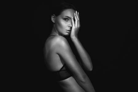 beautiful naked girl in Black studio. young woman in underwearの写真素材
