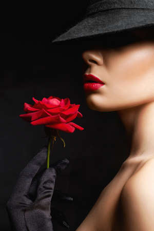Beautiful young Woman In Hat and Flower. Lovely girl with make-up and Red Rose. beauty portraitの写真素材