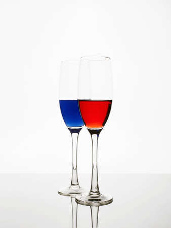red and blue liquids in glasses. beautiful still life. Wineglasses on the mirrorの写真素材