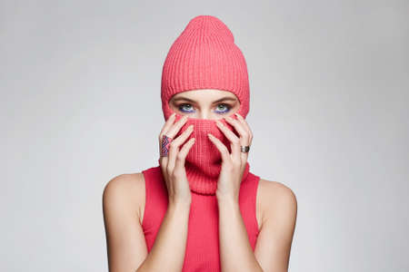 beautiful girl in red balaclava. New hat style. Trendy Pink Mask on pretty womanの写真素材