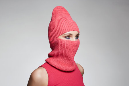 beautiful girl in red balaclava. New hat style. Trendy Mask on pretty womanの写真素材