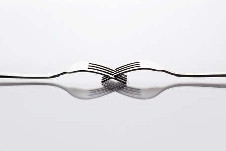 unusual still life of forks on a glass table. abstract minimalist composition. art object
