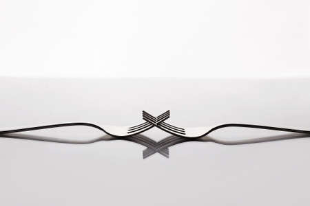unusual still life of forks on a glass table. abstract minimalist composition. art object