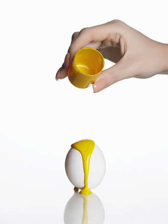 Easter egg coloring. Yellow paint runs down the egg. holidayの写真素材