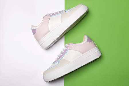 color trendy sneakers on green background. fashion shoes still life. gumshoes. stylish photo in the...