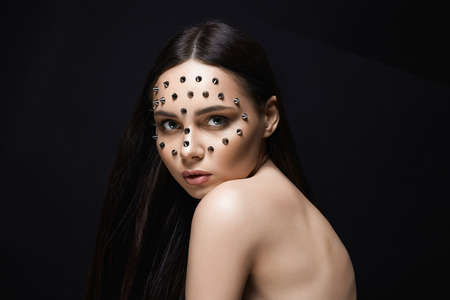 beautiful girl with steel spikes on her Face. Beautiful sexy woman with Halloween Make-up. beauty...