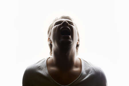 Screaming man in studio isolated white background. Emotion boy in a shirt. Cryの写真素材