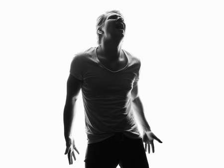Silhouette of sad boy. black and white portrait of screaming young manの写真素材