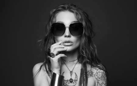 portrait of Beautiful sexy woman with tattoo. beauty tattooed girl in sunglasses and jewelry. cheerful modelの写真素材
