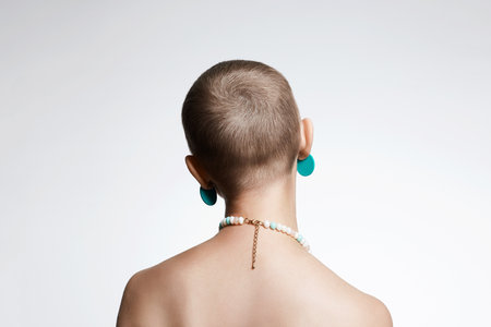 beautiful woman with short haircut. Back of naked bald Girl with Necklace and earrings