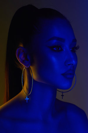 beautiful young woman in color lights. brunette girl studio portraitの写真素材