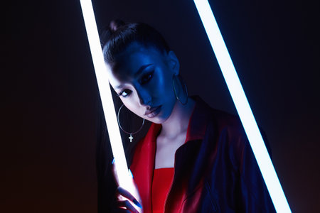 beautiful young woman with neon lamp. Pretty girl in color lights. studio portraitの写真素材