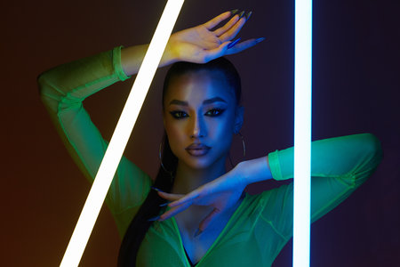 beautiful young woman with neon lamp. Dancer girl in color lights. studio portraitの写真素材