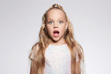 little girl in beautiful dress and make-up. Portrait of stylish pretty funny Child. Blondeの写真素材