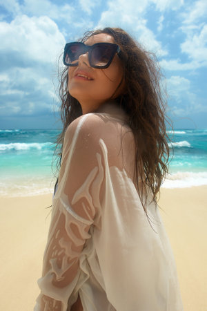 smiling Beautiful young woman on the beach. Happy girl in sunglasses. Summer vacation on sea coastの写真素材